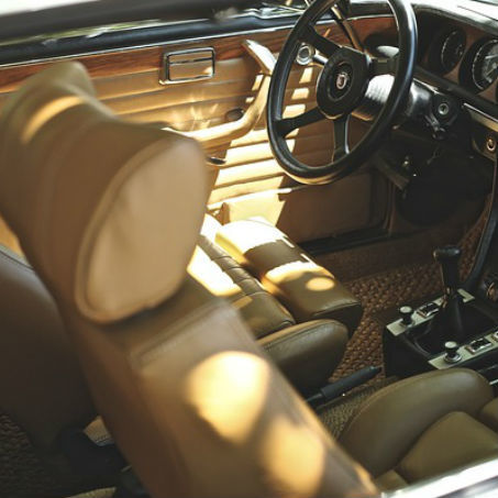 Custom tan leather upholstery repair on a classic car interior.